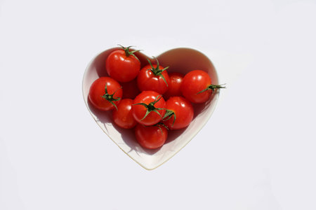 heart shape cherry tomatoes on white backgroundの写真素材