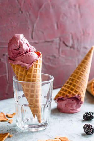 Blackberry ice cream filled waffle cones.の写真素材
