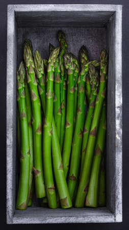 Fresh asparagus in a whitewashed rustic wooden boxの写真素材
