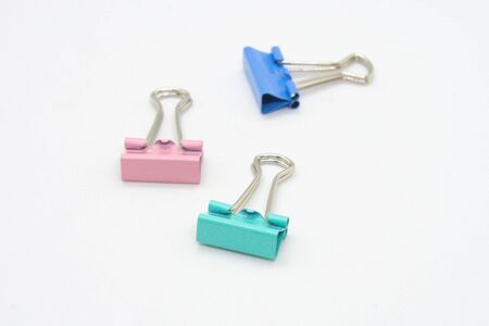 The binder clips color is turquoise blue and pink on a white background.の写真素材