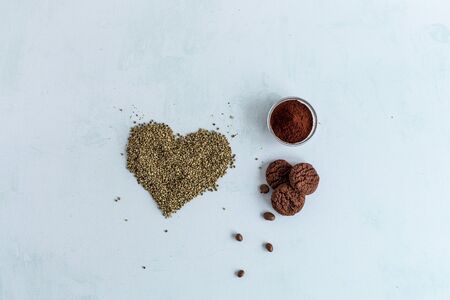 CBD cannabis cookies, cocoa and heart shaped hemp seeds on bright background. Medicinal marijuana in...