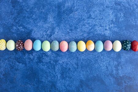 Easter eggs in line on dark blue background. Holiday decorations, Easter concept background.