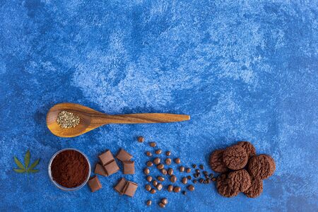 Cannabis cookies, cocoa, CBD oil, hemp seeds and coffee beans on dark blue background. Medicinal marijuana in food.の写真素材