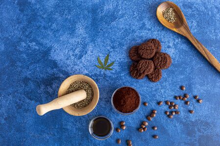 Cannabis cookies, cocoa, CBD oil and hemp seeds on dark blue background. Medicinal marijuana in food.の写真素材