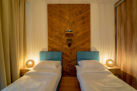 View of the tidy hotel bedroom without people, which is modernly decorated from an architectural...