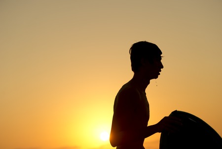 Silohette os a boy and his surfboard.の写真素材