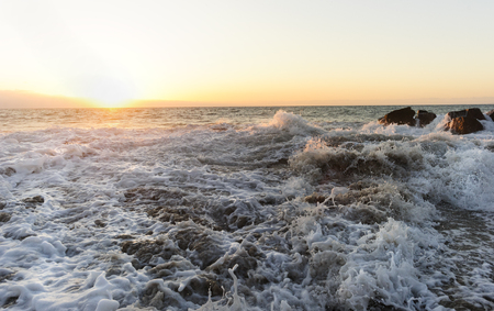 Waves crashing is an ocean sunset with frozen in time details of waves violently crashing among the ocean rocks. Photographed with Nikon D3s.の写真素材