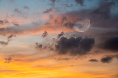A Full Moon is Rising in a Colorful Sunset Sky in a Vertical Image Format