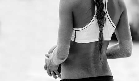 A Female Beach Volleyball Player is Getting Ready to Serve the Ballの写真素材