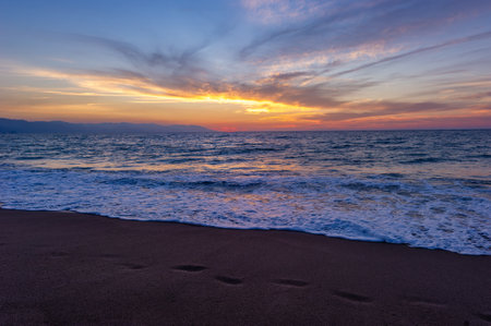 Footprints In The Sand Ocean Sunset With People in the Backgroundの写真素材