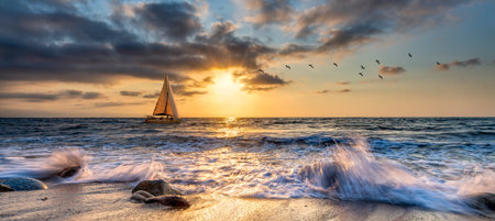 A Sailboat Is Sailing Along The Ocean With A Wave Breaking On Shoreの写真素材