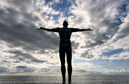 A Silhouette Of A Man With Outstretched Arms Looking Up To The Skyの写真素材