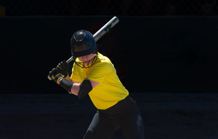 A Baseball Softball Player Is Swinging And Hitting The Ballの写真素材