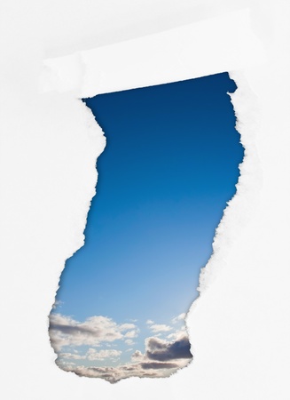 Torn paper ower sky with sun and cloudsの写真素材