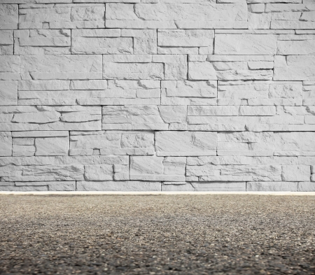 Brick wall on street and asphalt pathの写真素材