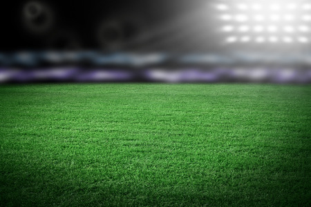 Sport stadium in spotlight with green grass fieldの写真素材