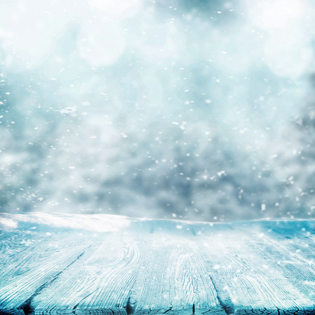 Snowing in winter time with wooden table for objectの写真素材