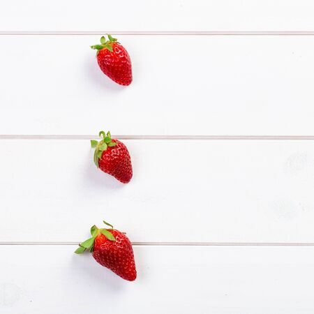 Three strawberries on wooden boardsの写真素材