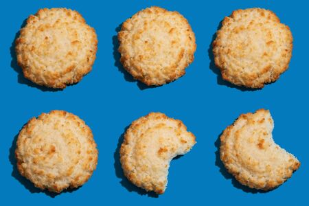 Some bitten coconut cookies as pattern on bluebackgroundの写真素材