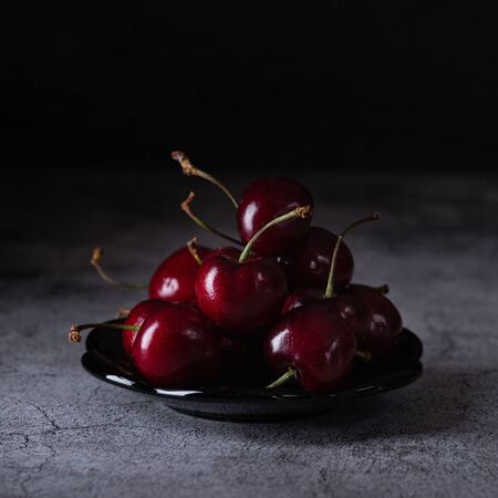 Red cherry in the dark on the tableの写真素材