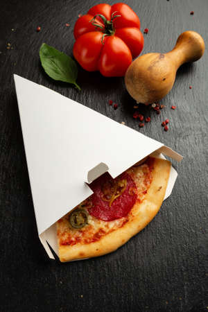 Piece of salami pizza in a boxの写真素材
