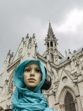 Genara listening to music, indifferent, to the splendid tower of the Basilica of the National Vow. Quito, Ecuador.の写真素材