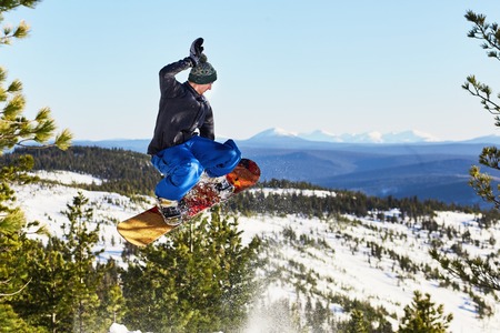 Flying snowboarder in the mountains