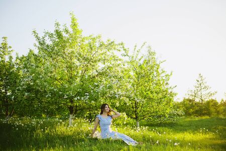 Beautiful woman enjoying daisy field, nice female lying down in the meadow of flowers, pretty girl relaxing outdoor, having fun, happy young lady and spring green nature, harmony and freedom conceptの写真素材