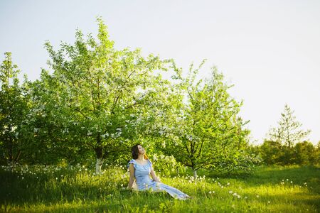 Beautiful woman enjoying daisy field, nice female lying down in the meadow of flowers, pretty girl relaxing outdoor, having fun, happy young lady and spring green nature, harmony and freedom conceptの写真素材