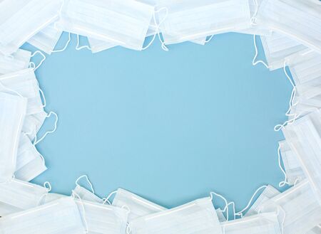 Medical hygienic mask, Face protective masks on blue background.Disposable surgical face mask protective against Coronovirus Covid-19,pollution, virus, flu.Healthcare medical surgical Flat lay patternの写真素材