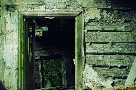 An open doorway abandoned and ruined hut.の写真素材