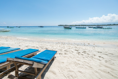 Tropical sandy beach with buildings and boats in a sea. Gili Trawangan, Indonesiaの写真素材