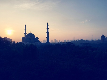Sunrise over silhouette mosque and Kuala Lumpur city skylineの素材