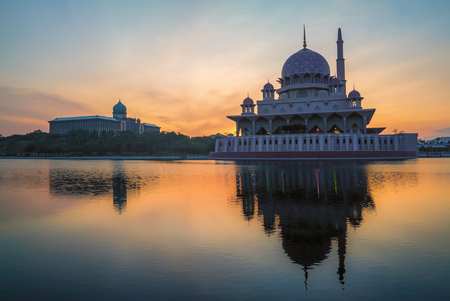 Beautiful Sunrise over a Mosque by the lake with colorful clouds and reflection.のeditorial素材