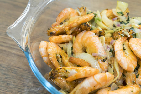 Boiled fried prawn in a bowl on a wooden tableの写真素材
