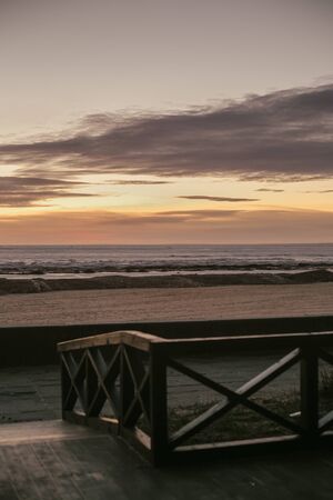 sunset at sea wooden fence purple clouds