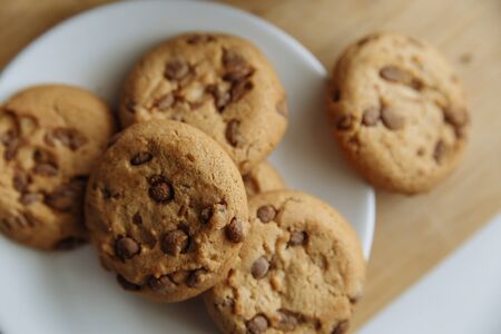 brown cookies on the white plate and coffee in white glass