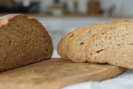 Sliced bread on a board on a white tableclothの写真素材