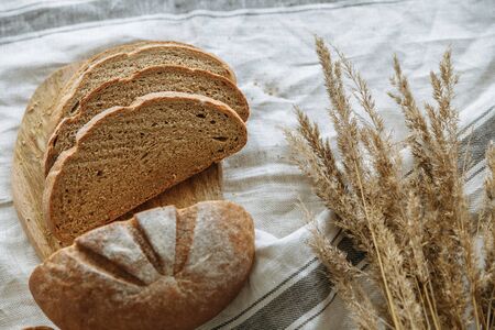 Sliced bread on a board on a white tableclothの写真素材