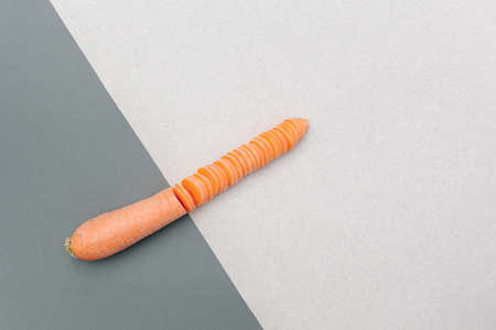 Cut in half carrots, slices on a gray-light background.の写真素材