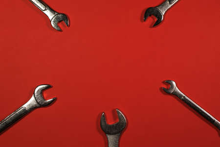 A lot of wrenches, chrome wrenches on a red background.の写真素材