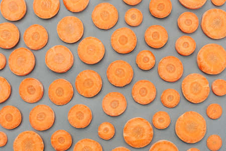 Many slices of juicy carrots on a gray background.の写真素材