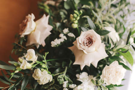 Bouquet with beige - pale purple roses with lush greenery.