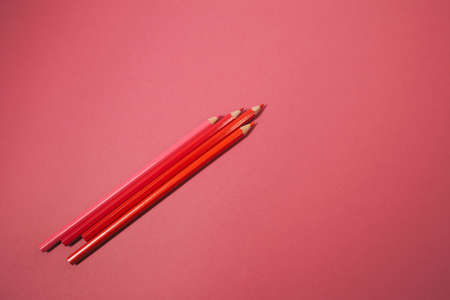 Lots of bright, colored pencils on a orange background full screen.の写真素材