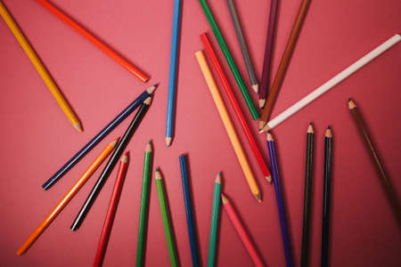 Lots of bright, colored pencils on a orange background full screen.の写真素材