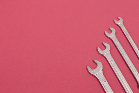 Many steel wrenches on an pink background full screen.の写真素材