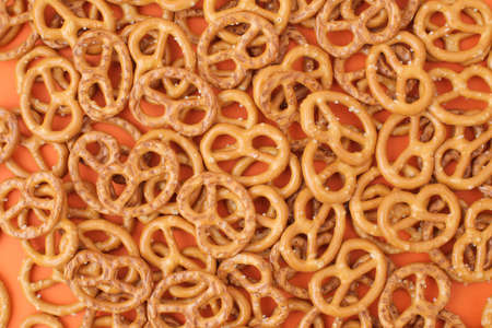 Lots of delicious, salty pretzels on a colored background, full screen.の写真素材