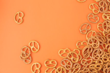 Lots of delicious, salty pretzels on a colored background, full screen.の写真素材