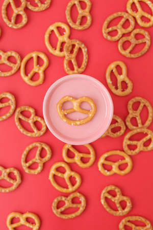 Lots of delicious, salty pretzels on a colored background, full screen.の写真素材