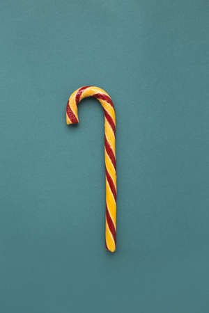 Christmas, sweet multi-colored candy cane stick on a blue background.の写真素材